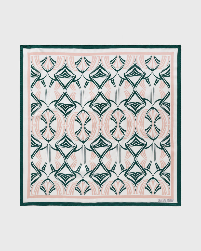 Product shot of a silk scarf printed with a dusky pink and forest green art nouveau pattern